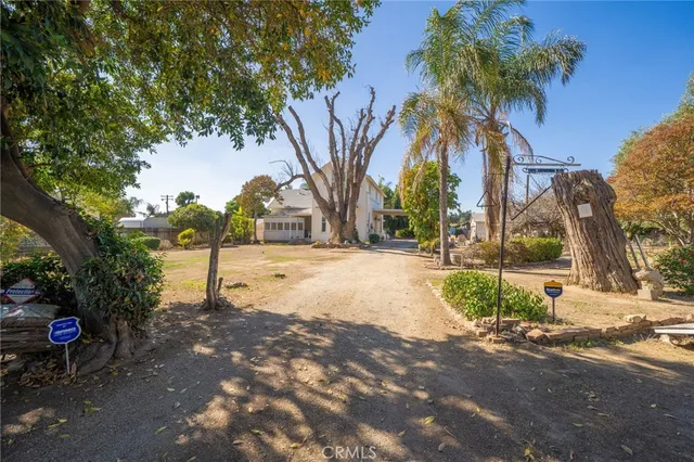 a view of a house with a yard and coconut trees