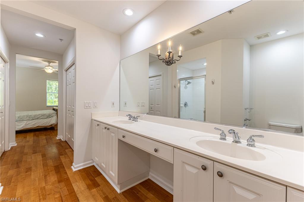 3975 Deer Crossing Court, Unit 102 Naples, FL 34114 - Photo 24 of 32 a spacious bathroom with a double vanity sink double and mirror