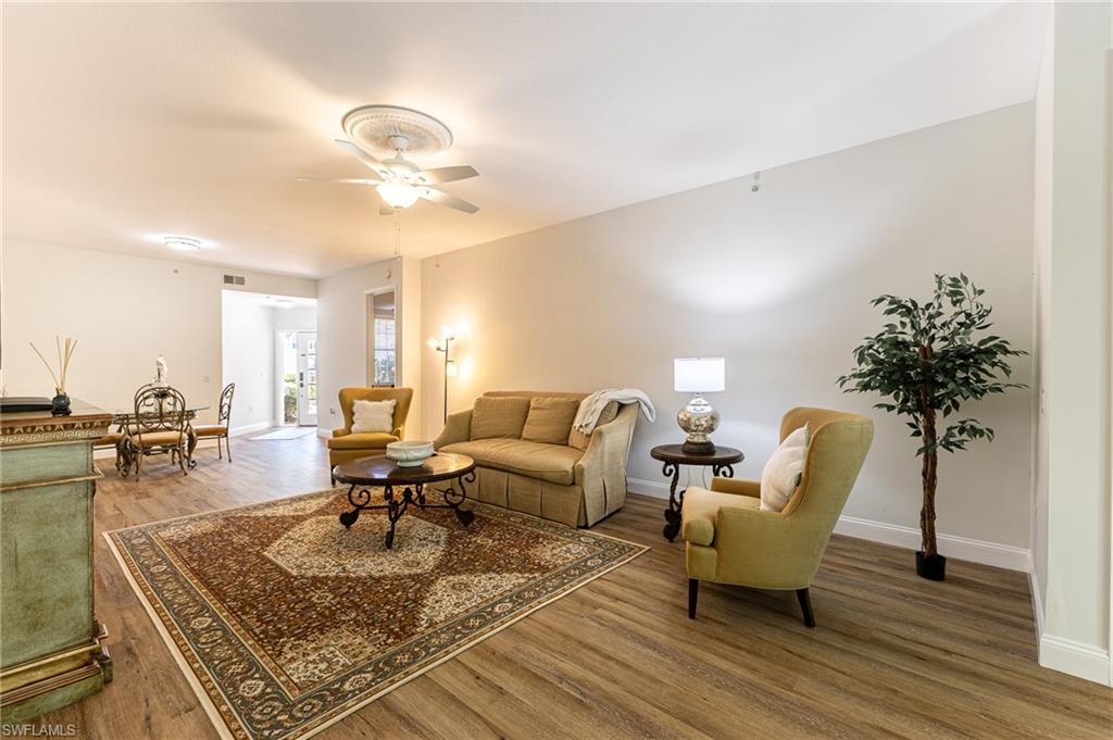 3975 Deer Crossing Court, Unit 102 Naples, FL 34114 - Photo 28 of 32 a living room with furniture and a chandelier