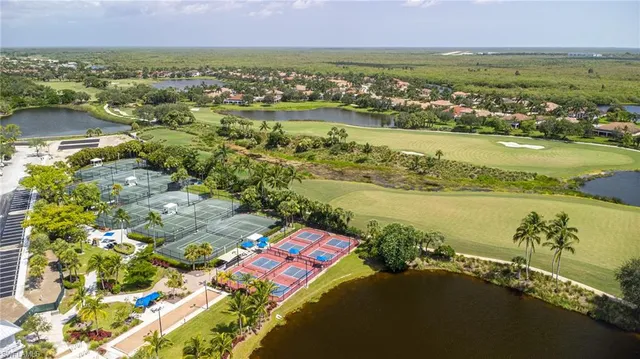 an aerial view of ocean and residential houses with outdoor space
