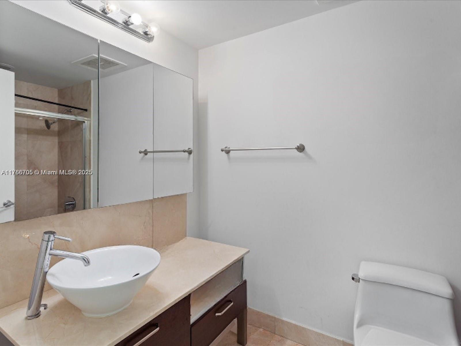 218 Southeast 14th Street, Unit 1203 Miami, FL 33131 - Photo 13 of 22 a bathroom with a sink toilet and vanity