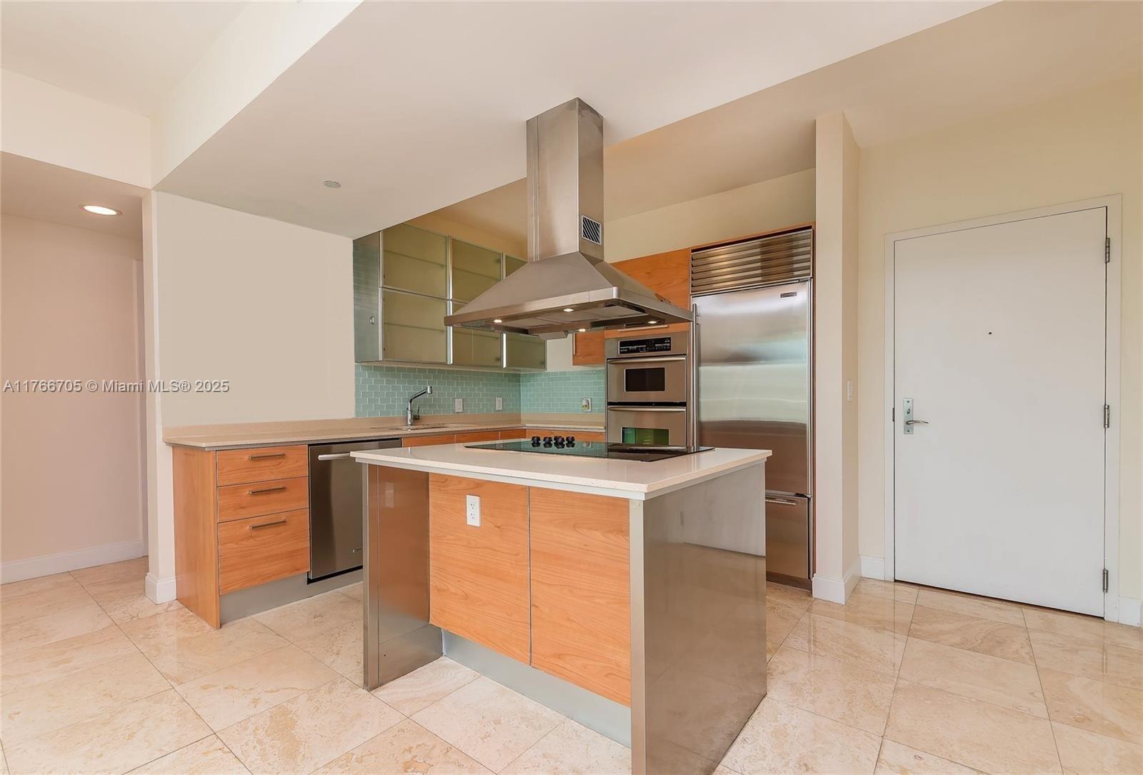 218 Southeast 14th Street, Unit 1203 Miami, FL 33131 - Photo 3 of 22 a kitchen with a stove top oven and cabinets