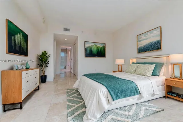 a bedroom with a large bed and a flat screen television