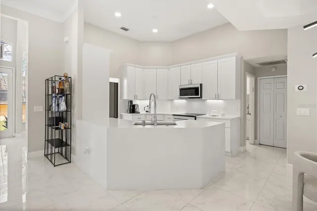 a large white kitchen with cabinets and stainless steel appliances