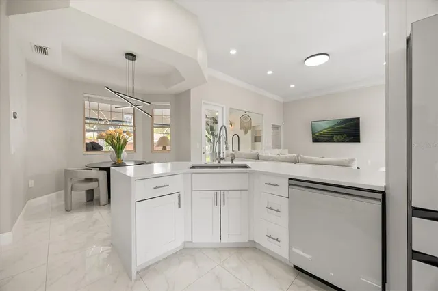 a kitchen with white cabinets and sink