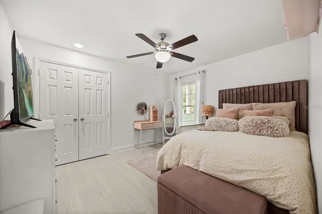 a bedroom with a large bed and a chandelier