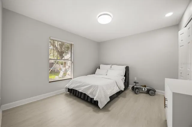 a spacious bedroom with a bed and a window