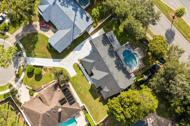an aerial view of a house with swimming pool and outdoor seating