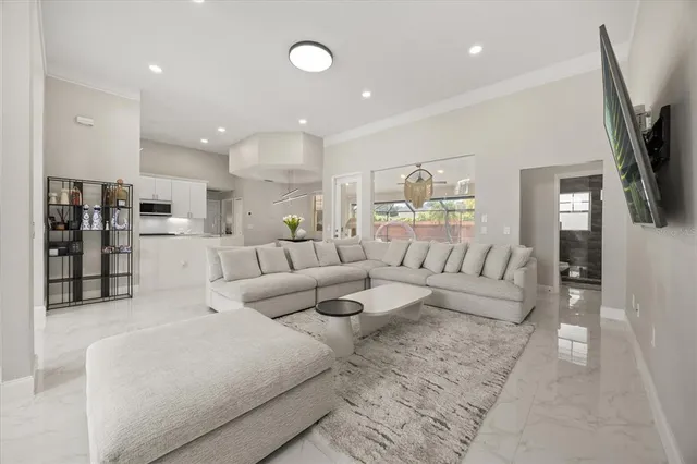 a living room with furniture flat screen tv and large window
