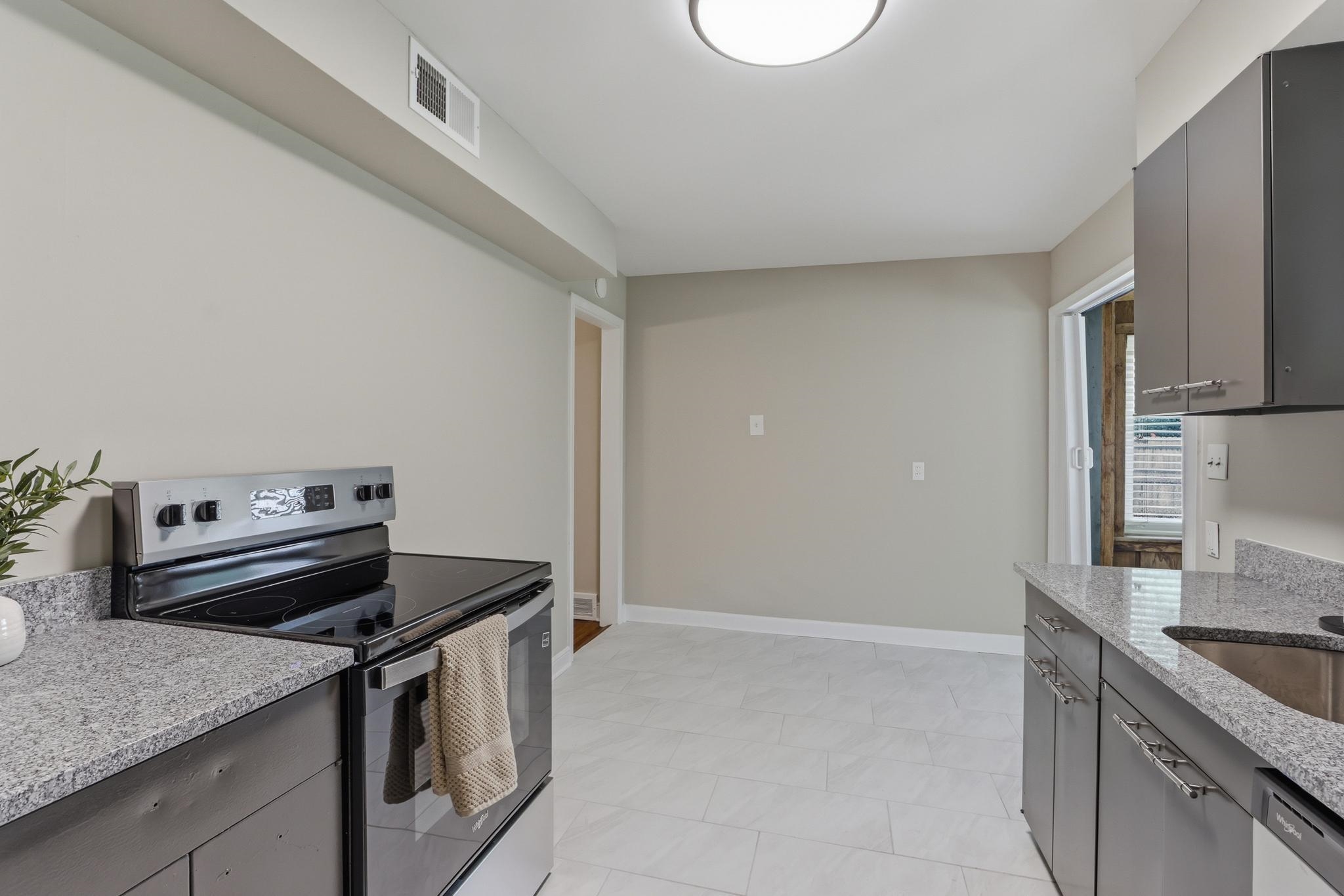 312 Fernway Road Memphis, TN 38117 - Photo 18 of 38 Kitchen featuring stainless steel appliances, light stone countertops, and gray cabinets