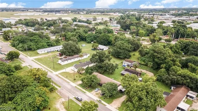 an aerial view of residential houses with outdoor space and trees