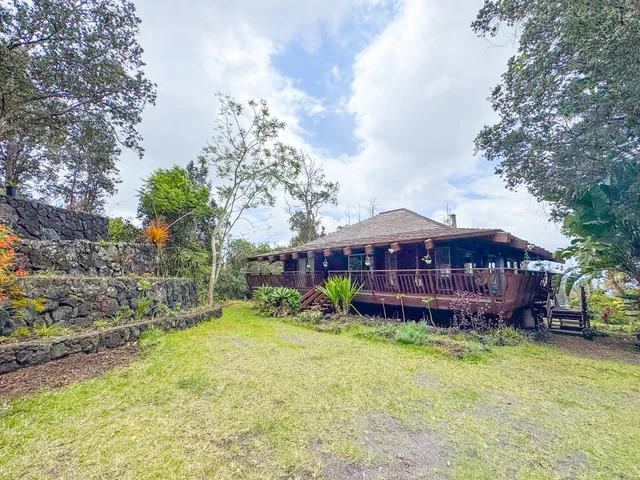 a view of a house with a yard and sitting area