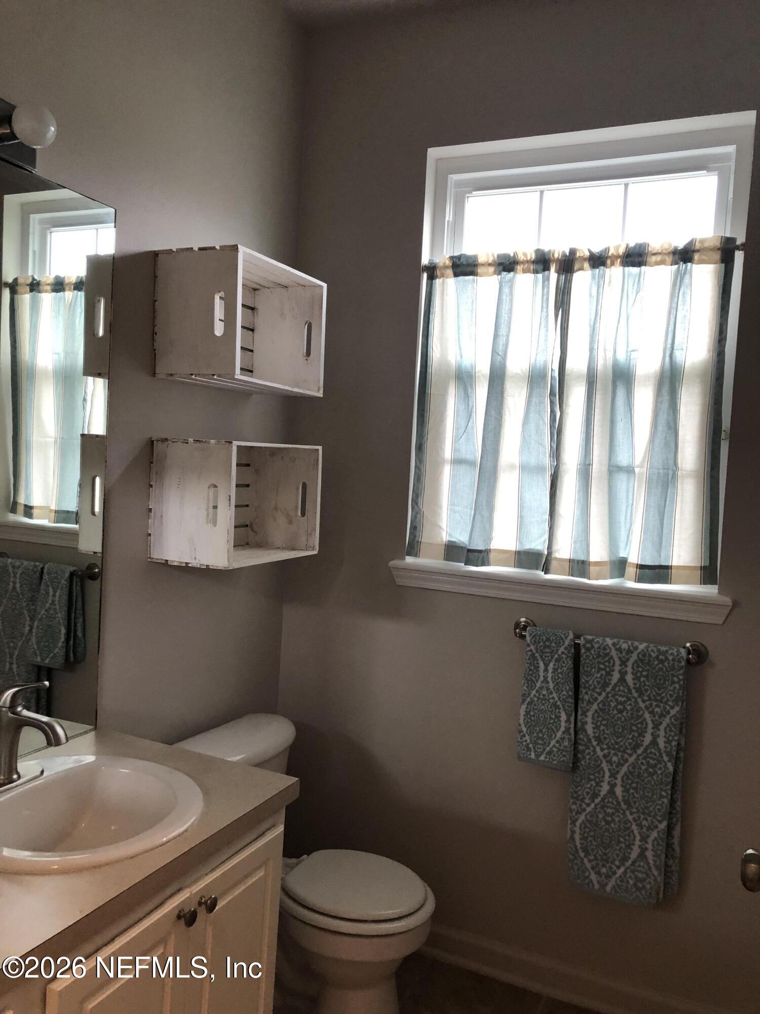 7990 Baymeadows Road, Unit 803 Jacksonville, FL 32256 - Photo 16 of 25 a bathroom with a toilet a sink and mirror