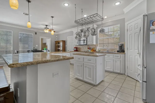 a large kitchen with cabinets and chairs