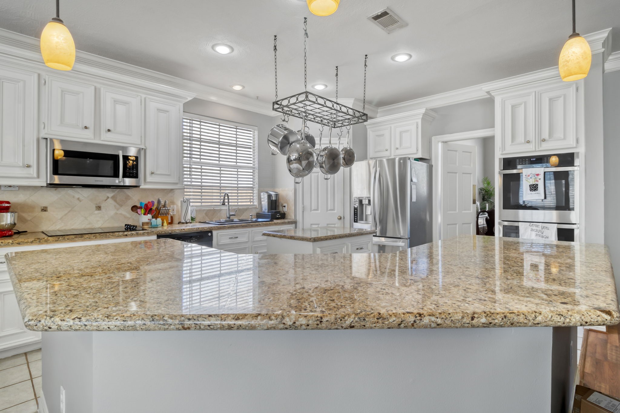 18106 Briden Oak Court Spring, TX 77379 - Photo 13 of 31 a kitchen with kitchen island granite countertop a large counter top cabinets appliances and a center island