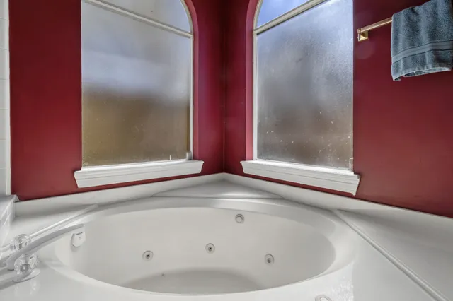 a bathroom with bathtub and a window