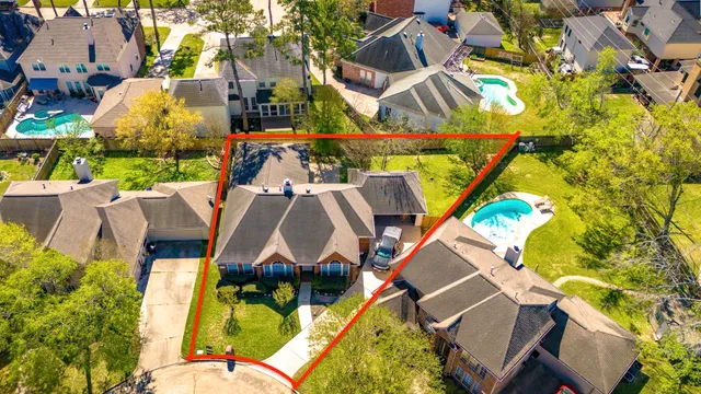 an aerial view of a house with a garden and swimming pool