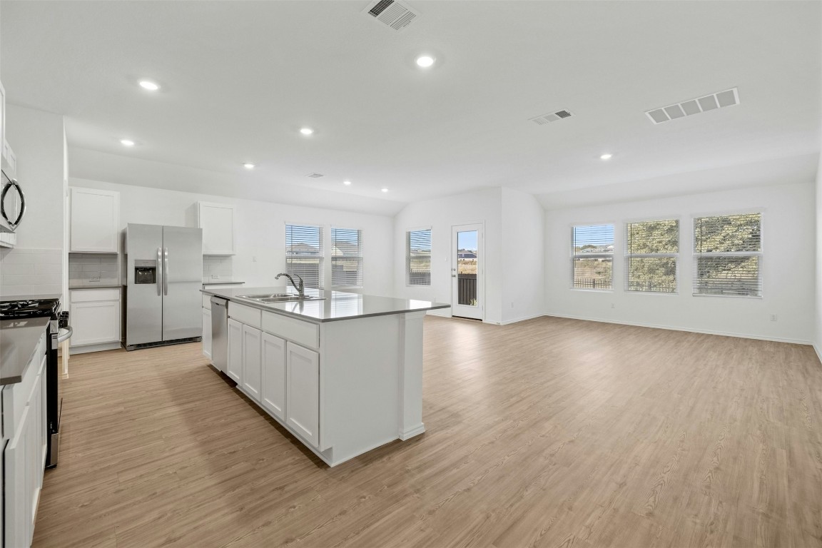 1804 Boggy Crk Rnch Road Georgetown, TX 78628 - Photo 4 of 28 a large white kitchen with stainless steel appliances granite countertop a large counter top a wooden floors and a large window