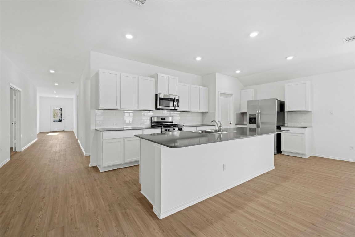 1804 Boggy Crk Rnch Road Georgetown, TX 78628 - Photo 9 of 28 a kitchen with stainless steel appliances a refrigerator a stove top oven and white walls