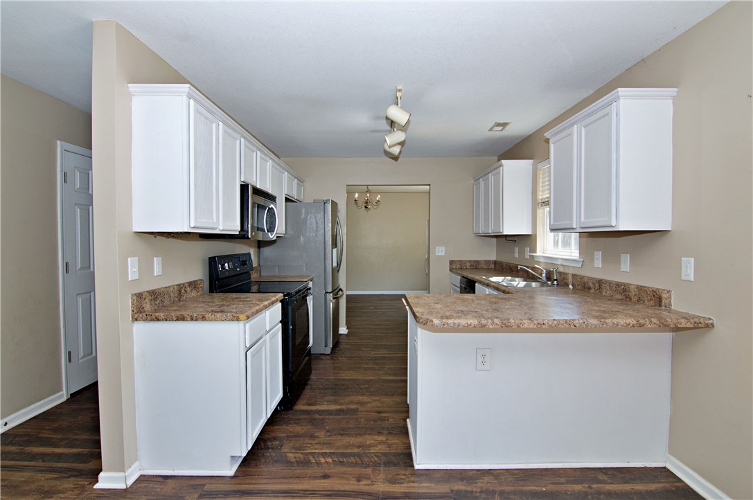 305 North Chestnut Street Seneca, SC 29678 - Photo 16 of 44 A functional kitchen with warm-toned countertops and durable wood-look flooring.