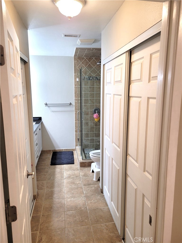 28162 Sloan Canyon Road, Unit A Castaic, CA 91384 - Photo 13 of 30 a bathroom with a glass door shower and a toilet