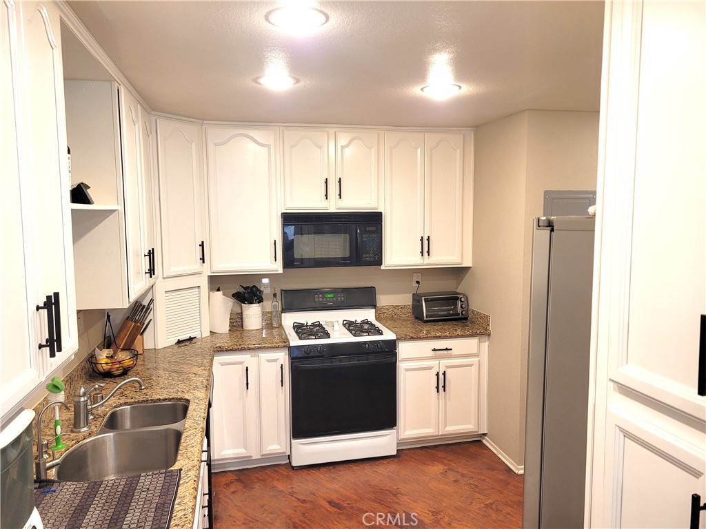 28162 Sloan Canyon Road, Unit A Castaic, CA 91384 - Photo 6 of 30 a kitchen with a sink stove and cabinets
