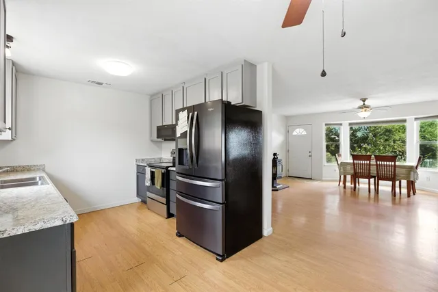 a kitchen with granite countertop a refrigerator and a stove top oven