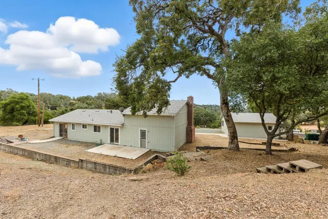 a view of a house with a yard and sitting area