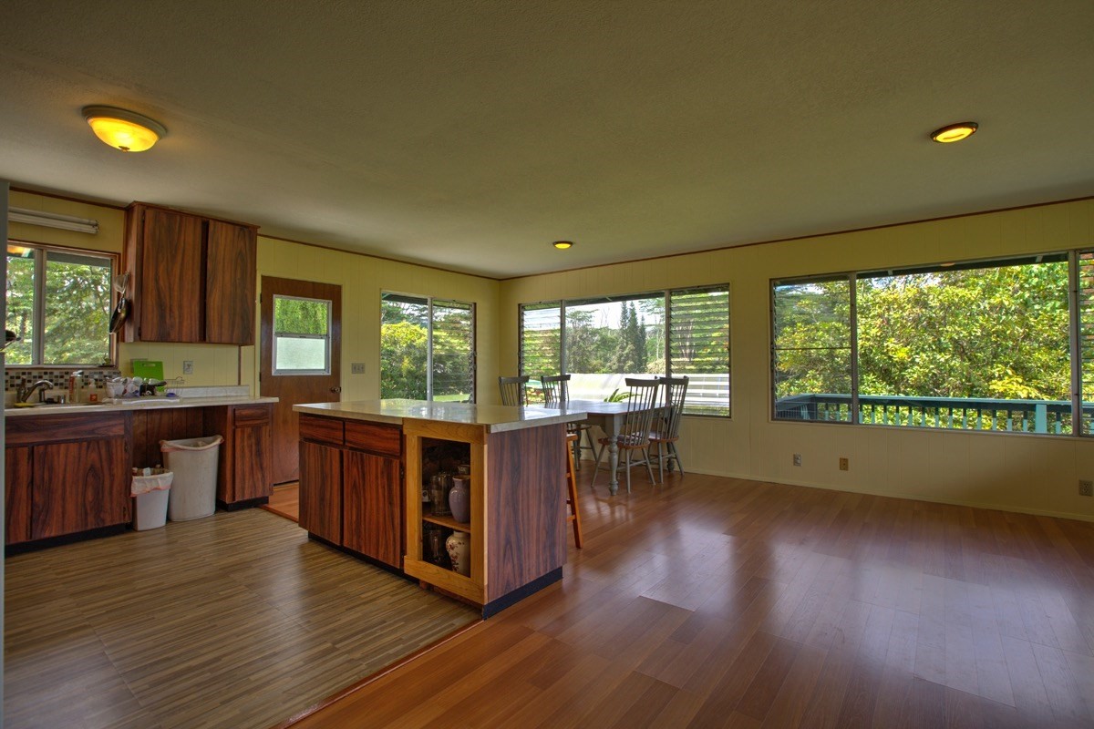 60 Hoaka Road Hilo, HI 96720 - Photo 5 of 24 a open kitchen with stainless steel appliances granite countertop a refrigerator a sink dishwasher a stove and a dining table with wooden floor