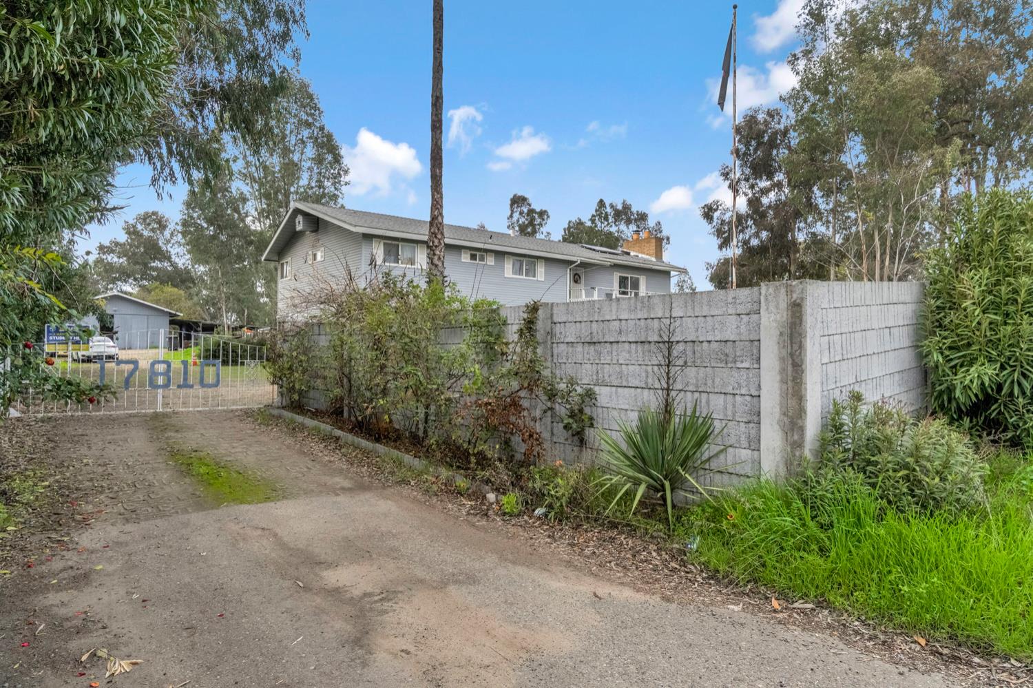 17810 Road 26 Madera, CA 93638 - Photo 2 of 39 a view of a brick house with a small yard and large trees