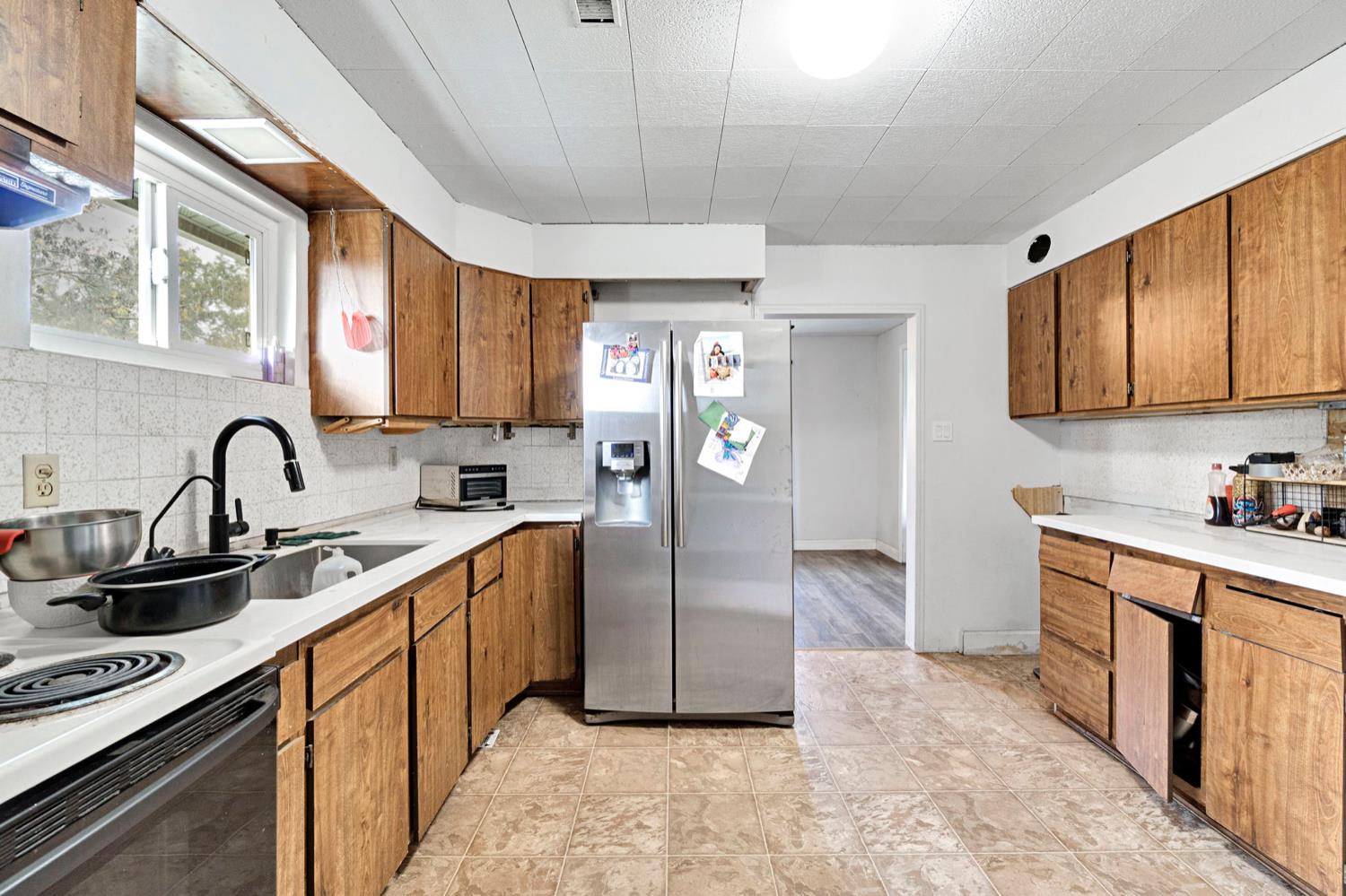 17810 Road 26 Madera, CA 93638 - Photo 25 of 39 a kitchen with stainless steel appliances a sink a stove a refrigerator cabinets and a window