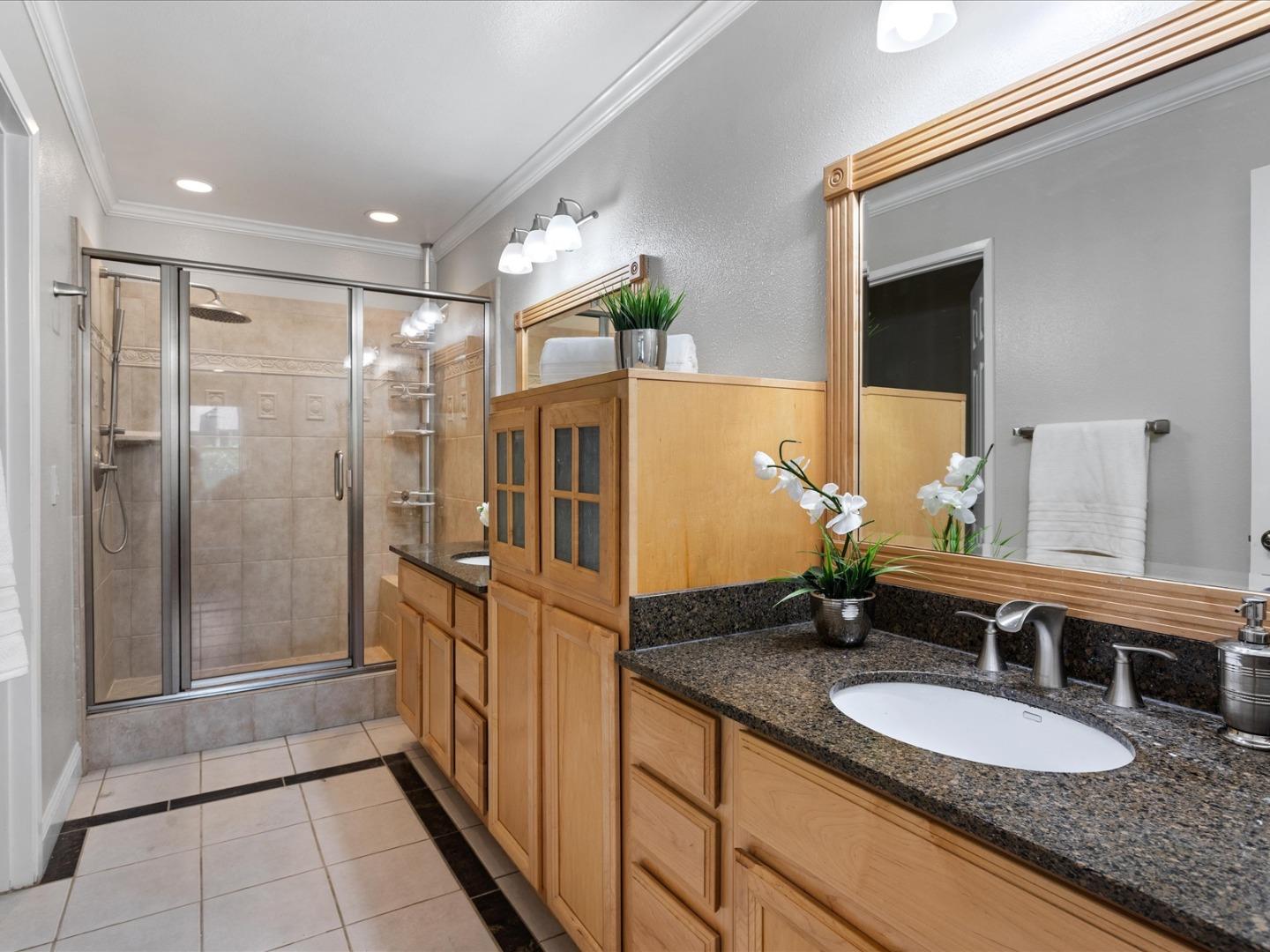 821 Pinehurst Place San Ramon, CA 94583 - Photo 19 of 26 a bathroom with a granite countertop sink a mirror and shower