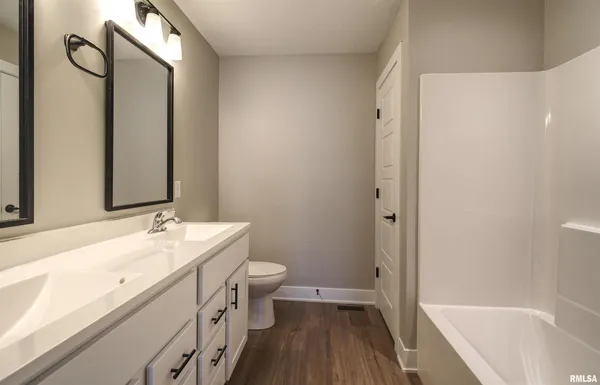 a bathroom with a sink a toilet and a large mirror
