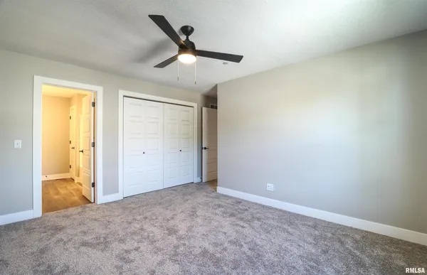 an empty room with closet and windows
