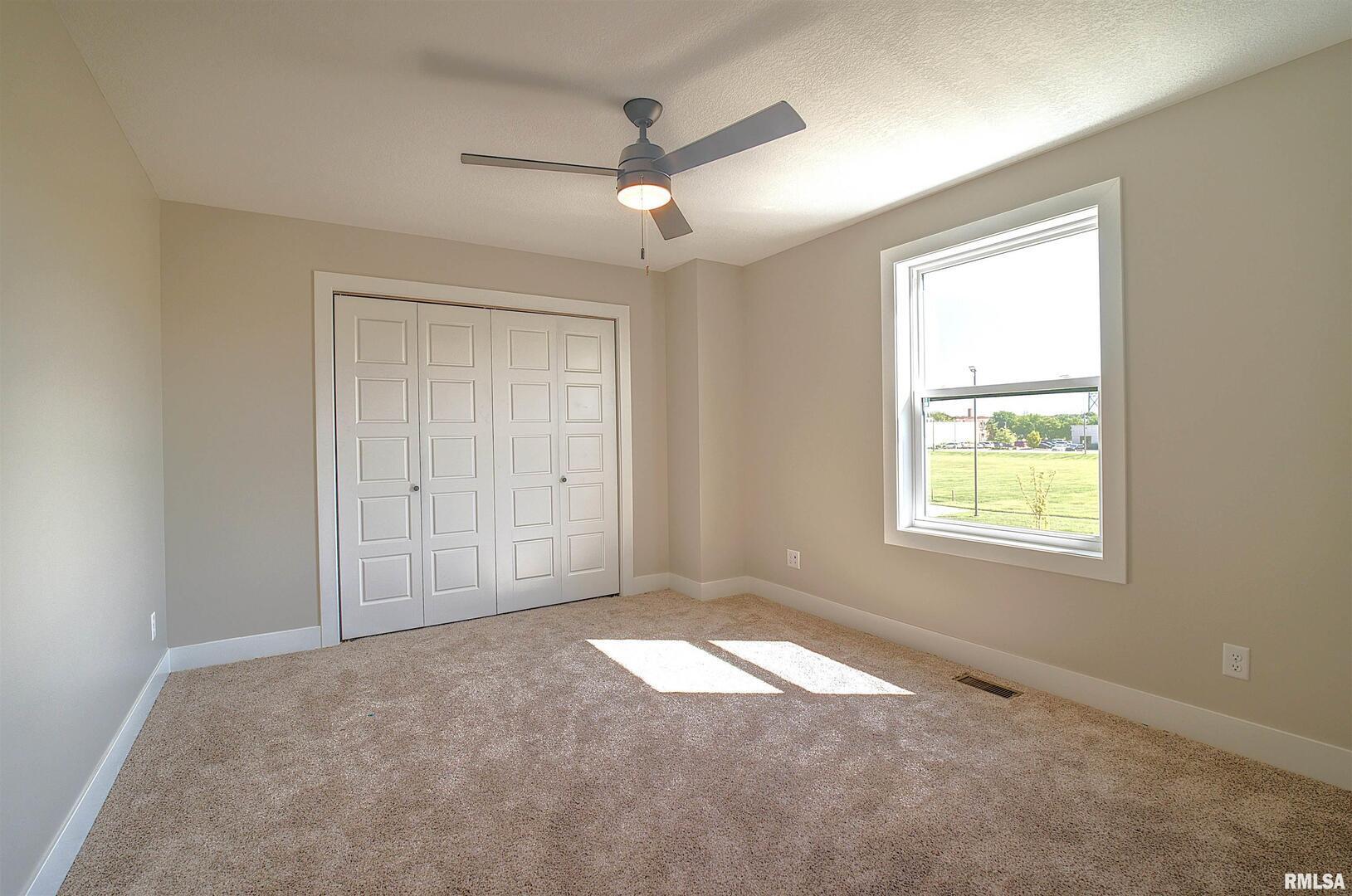 1004 South 4th Street Clinton, IA 52732 - Photo 9 of 18 en empty room with windows and chandelier fan