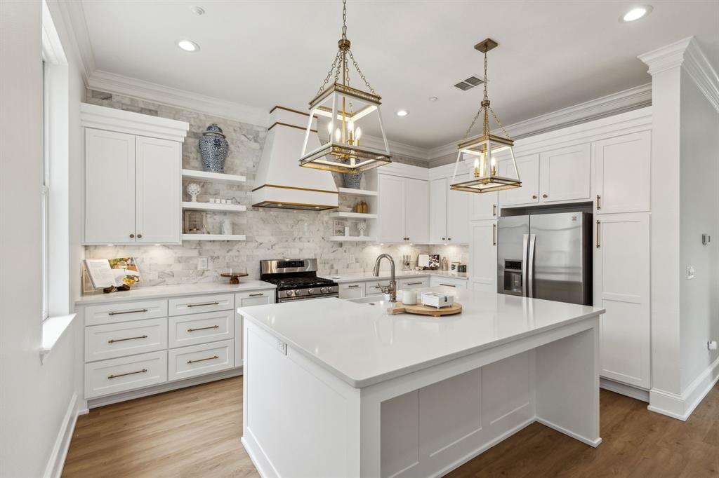 a kitchen with kitchen island granite countertop a sink cabinets and stainless steel appliances