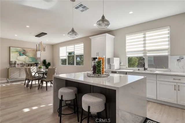 a kitchen with granite countertop a table chairs sink and cabinets