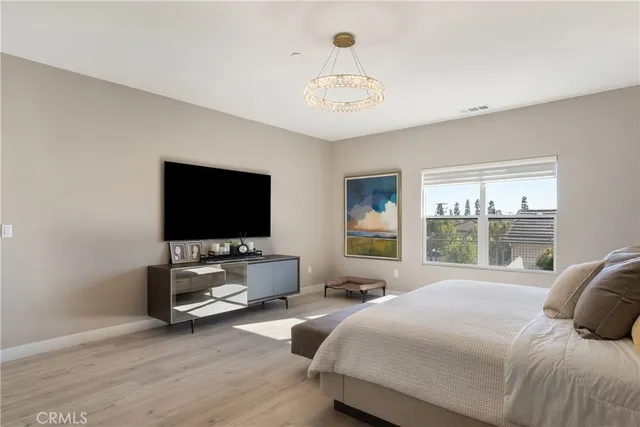 a spacious bedroom with a bed and a chandelier