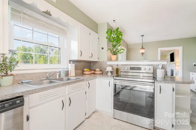 a kitchen with granite countertop a sink stainless steel appliances and cabinets