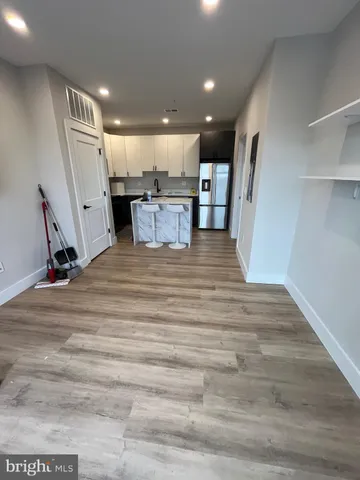 a view of kitchen with kitchen island wooden floor center island and appliances