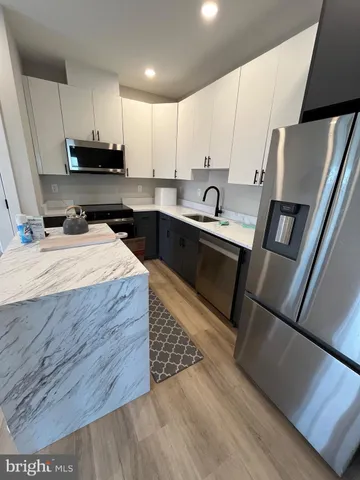 a kitchen with stainless steel appliances kitchen island granite countertop a sink stove and refrigerator