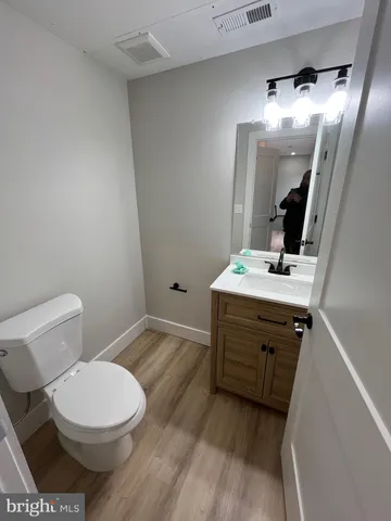a bathroom with a sink a toilet a mirror and vanity