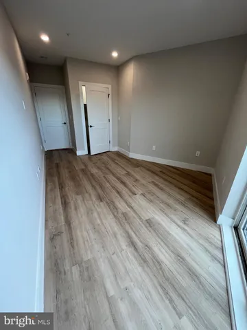 an empty room with wooden floor and a window