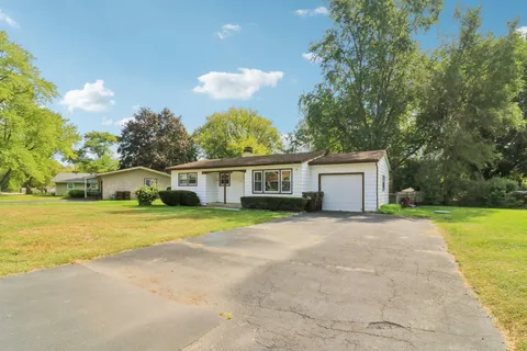a front view of a house with a yard and trees