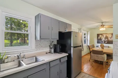 a kitchen with a refrigerator a sink and white cabinets
