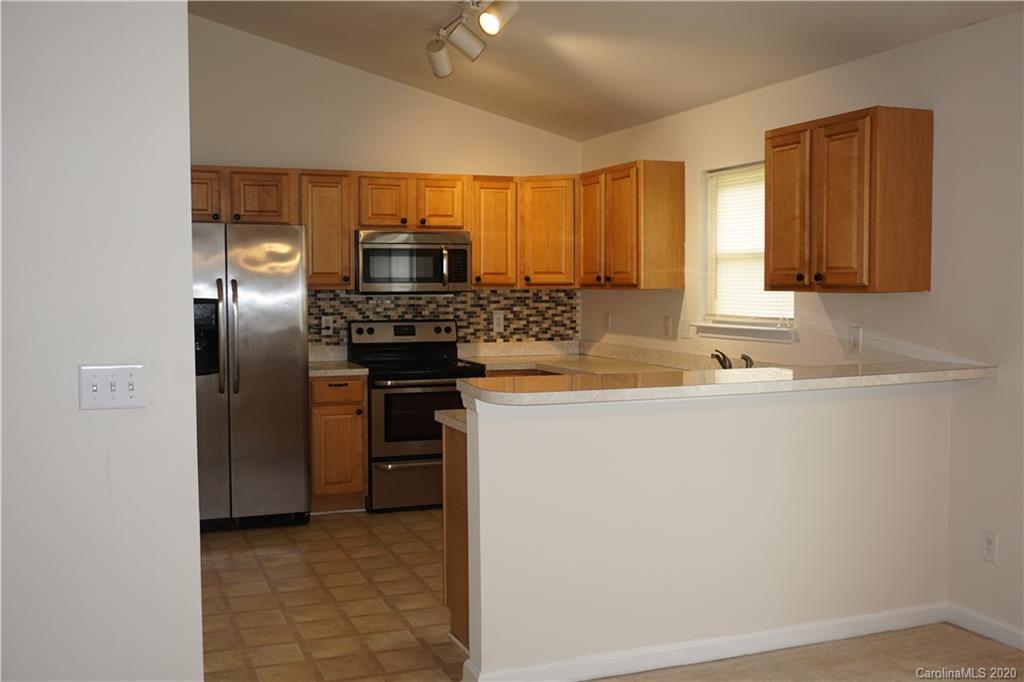 4121 Oakwood Road Charlotte, NC 28269 - Photo 3 of 15 a kitchen with stainless steel appliances granite countertop a refrigerator and a sink