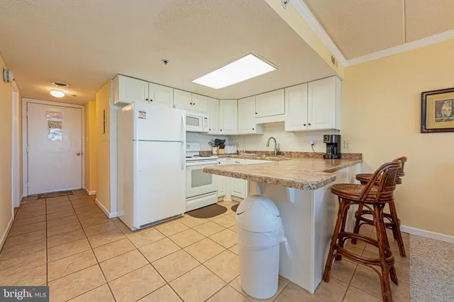 a kitchen with a refrigerator a counter space and a dining table