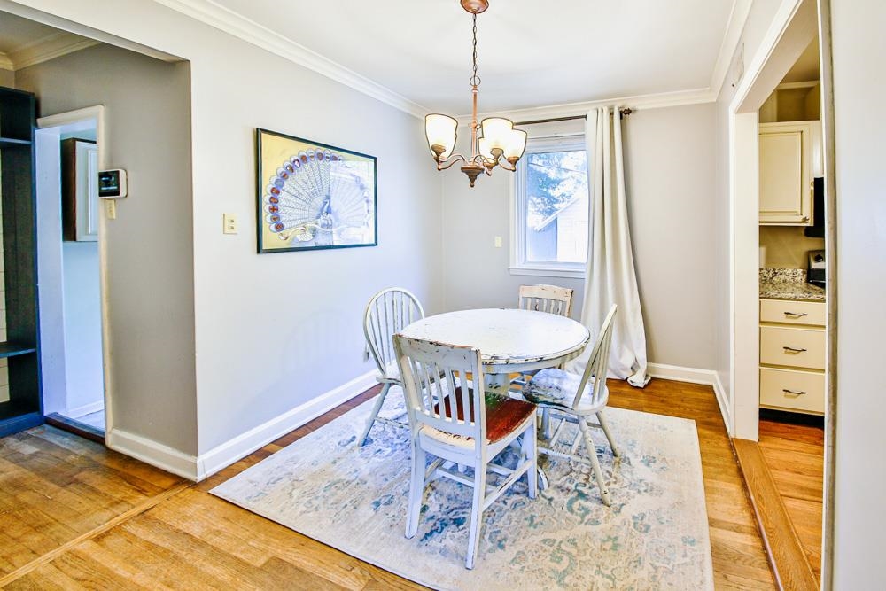 4964 Sequoia Road Memphis, TN 38117 - Photo 6 of 18 a dining room with wooden floor and a chandelier