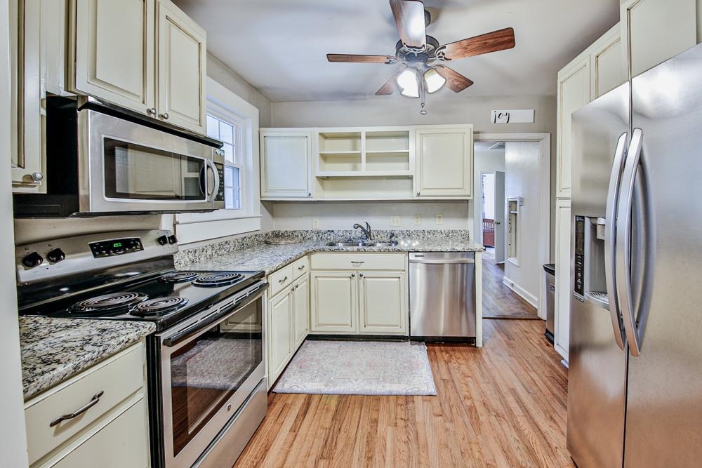 4964 Sequoia Road Memphis, TN 38117 - Photo 7 of 18 a kitchen with stainless steel appliances granite countertop a stove a sink and a refrigerator