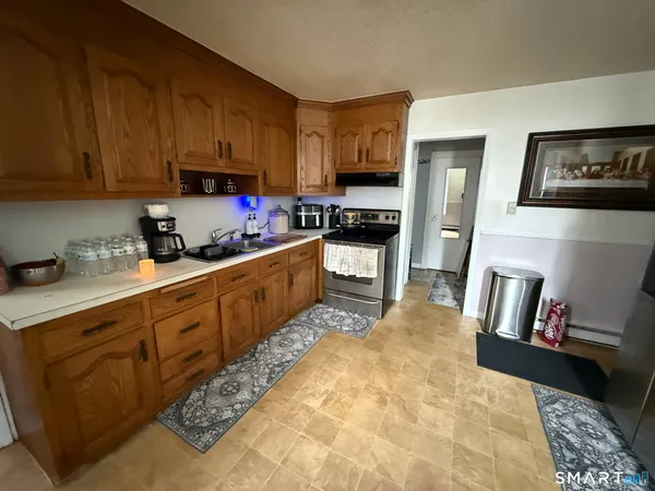 a kitchen with stainless steel appliances granite countertop a stove a sink a refrigerator and cabinets